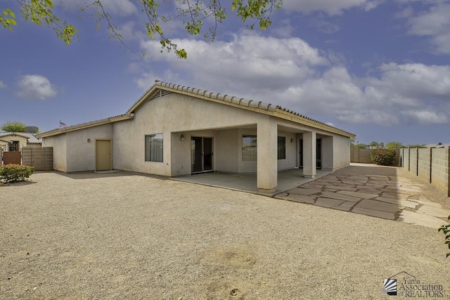 back of house featuring a patio, a fenced backyard, and stucco siding