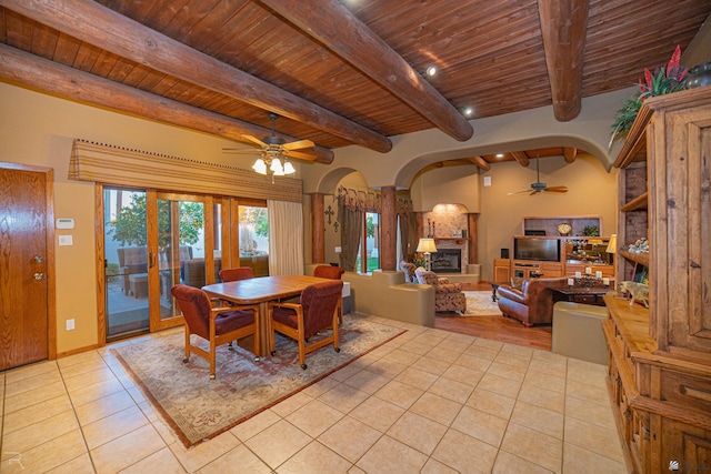 dining area with beamed ceiling, light tile patterned floors, wooden ceiling, and ceiling fan