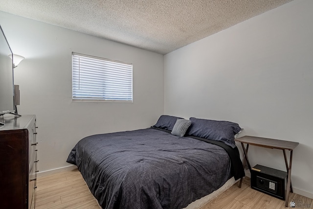 bedroom featuring light wood-type flooring and a textured ceiling