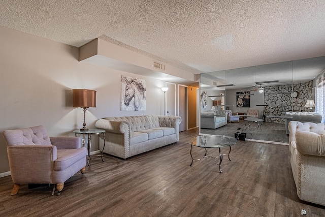 living room with hardwood / wood-style flooring, ceiling fan, and a textured ceiling