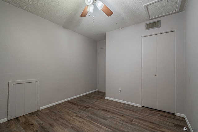 unfurnished bedroom with ceiling fan, dark hardwood / wood-style flooring, and a textured ceiling