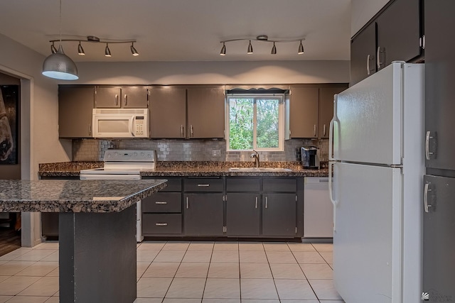 kitchen with decorative backsplash, white appliances, sink, hanging light fixtures, and light tile patterned flooring