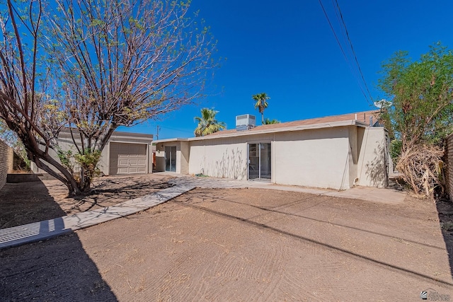 single story home featuring a garage and central AC unit