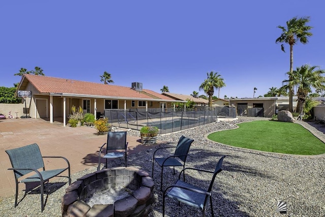 back of house featuring a fenced in pool, a yard, a patio, fence, and a fire pit