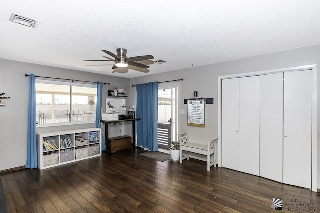 miscellaneous room featuring hardwood / wood-style flooring, ceiling fan, visible vents, and a textured ceiling