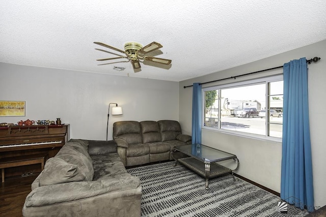 living area with a ceiling fan, a textured ceiling, and wood finished floors