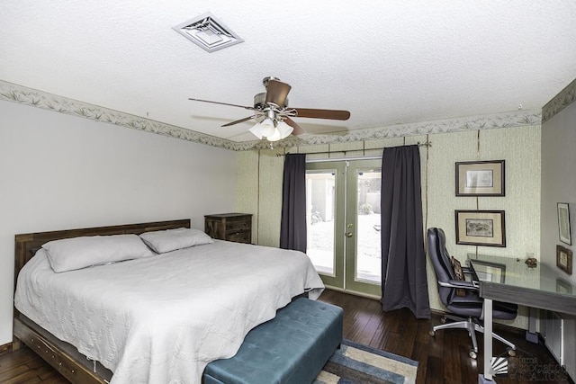 bedroom featuring dark wood-style floors, french doors, visible vents, a textured ceiling, and access to outside