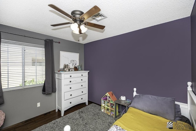 bedroom with a textured ceiling, ceiling fan, and wood finished floors