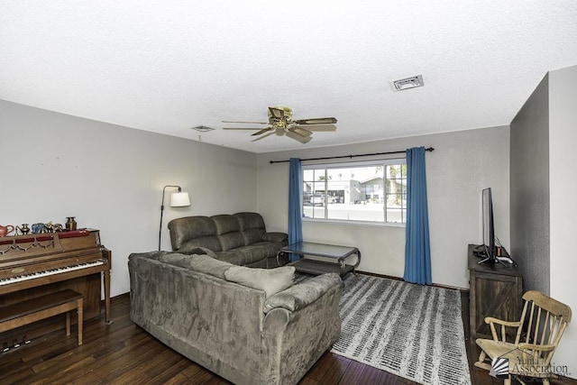 living area featuring a ceiling fan, visible vents, and wood finished floors