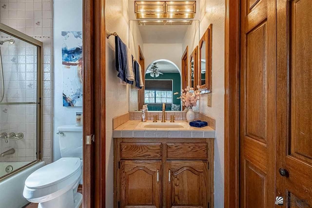 full bathroom featuring shower / bath combination with glass door, ceiling fan, vanity, and toilet