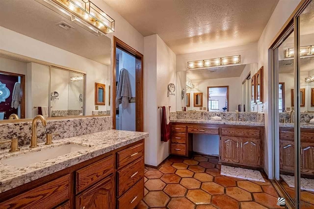 bathroom featuring tile patterned floors, vanity, and a textured ceiling