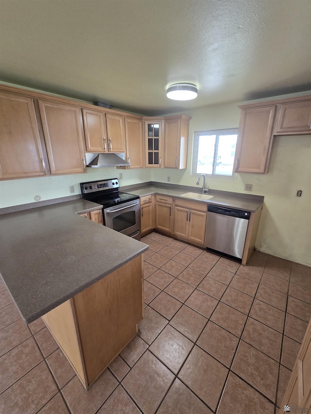 kitchen with sink, light tile patterned floors, kitchen peninsula, stainless steel appliances, and light brown cabinets