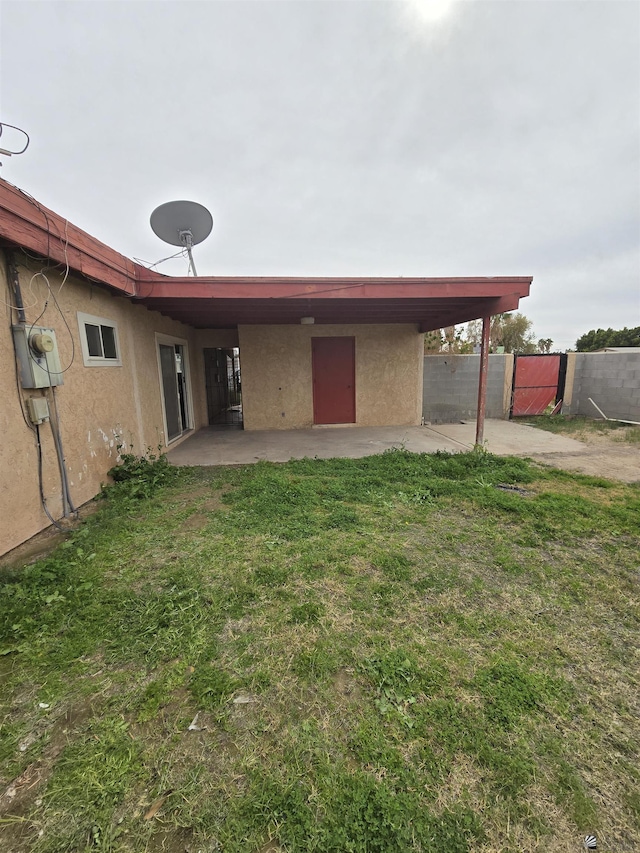 rear view of property featuring a patio and a lawn