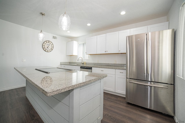 kitchen with white cabinetry, stainless steel appliances, decorative light fixtures, light stone counters, and a center island