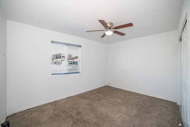 unfurnished room with ceiling fan and carpet flooring