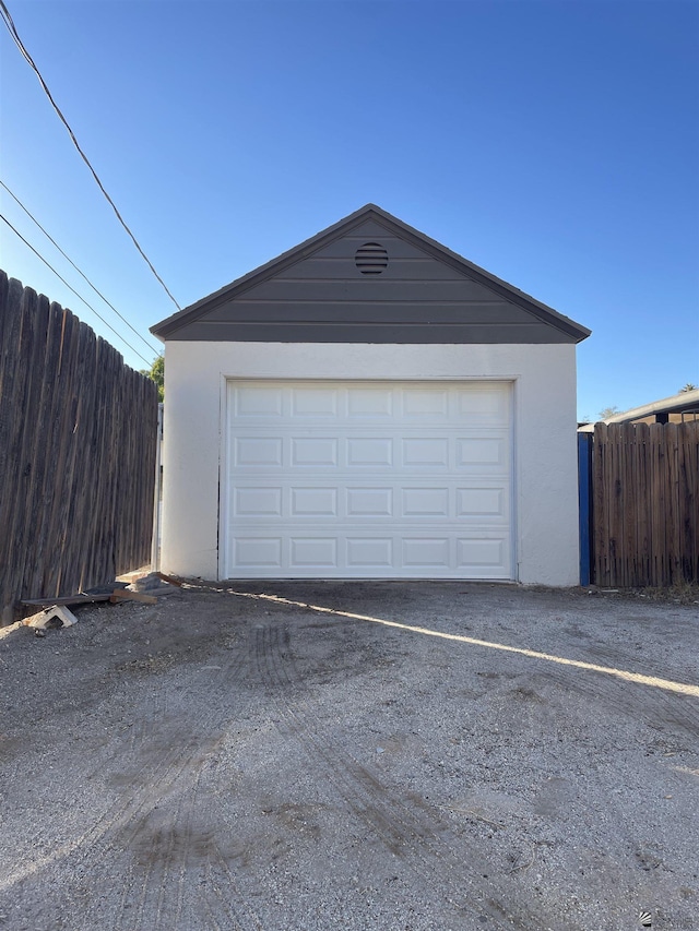 detached garage with fence and driveway