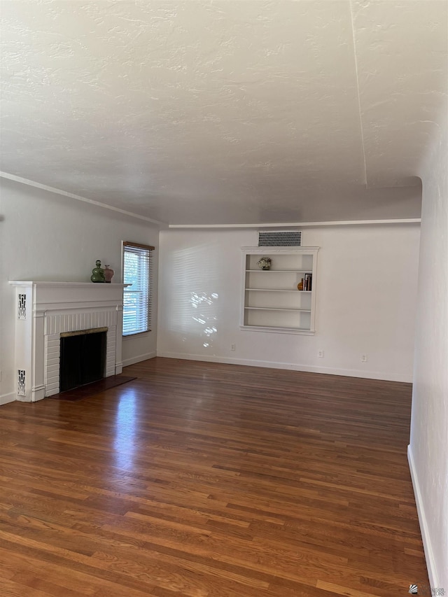 unfurnished living room featuring wood finished floors, a fireplace, baseboards, and a textured ceiling