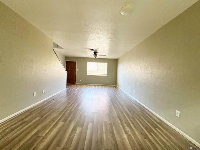 empty room featuring ceiling fan, a textured ceiling, and hardwood / wood-style flooring