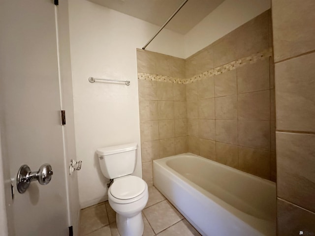 bathroom featuring tile patterned flooring, toilet, and tiled shower / bath