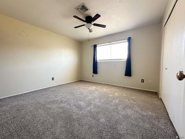 empty room with ceiling fan and carpet floors