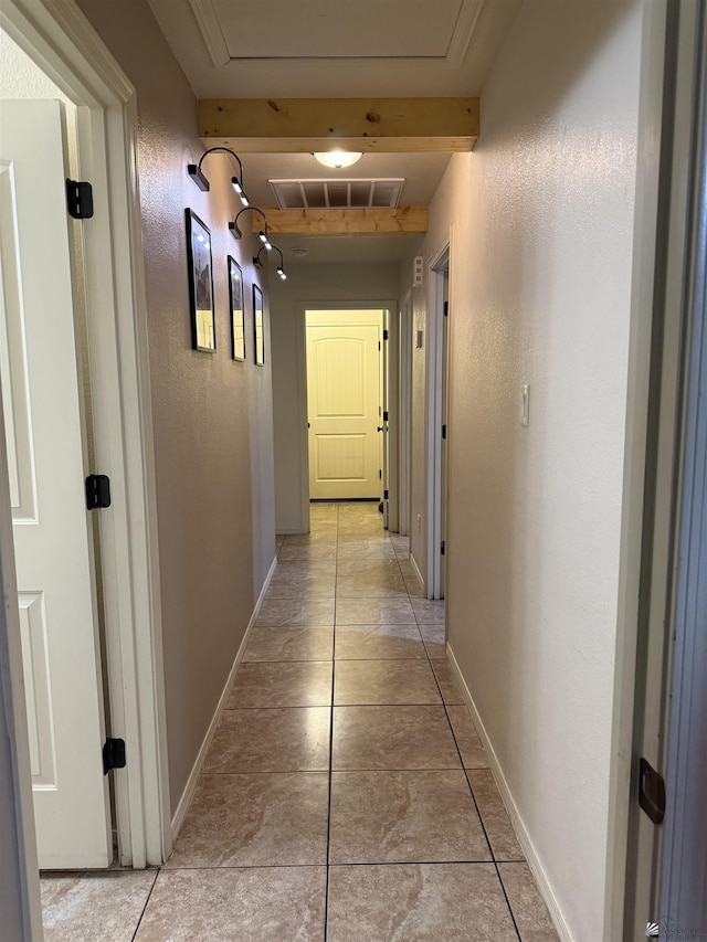 hall with baseboards, visible vents, and beamed ceiling