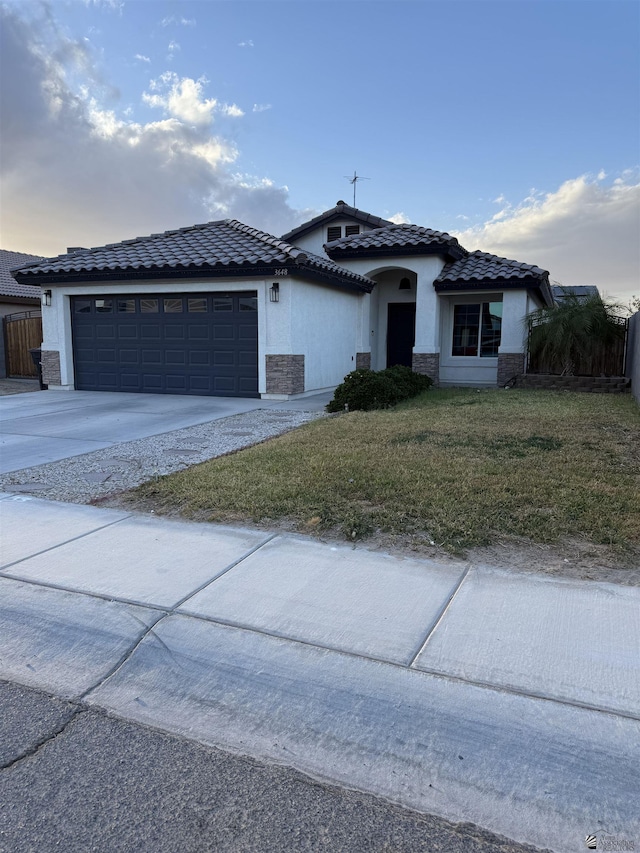 view of front facade featuring an attached garage, a front lawn, concrete driveway, and stucco siding