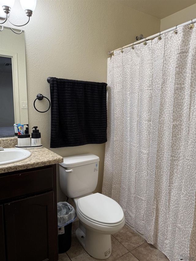 full bathroom with toilet, vanity, and tile patterned floors