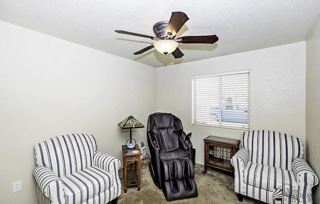 sitting room featuring ceiling fan, light colored carpet, and a textured ceiling