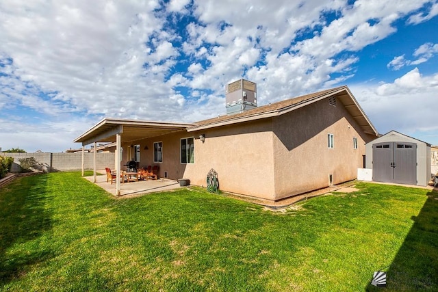 back of property with a lawn, central AC, a patio, and a shed