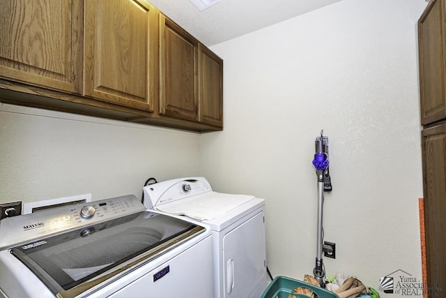 laundry area with washer and dryer and cabinets