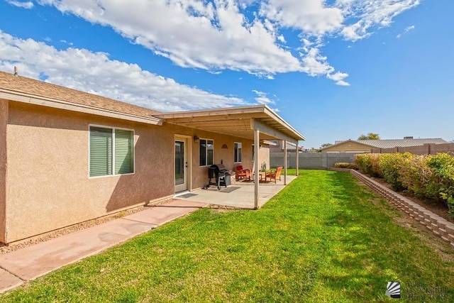 rear view of house with a lawn and a patio