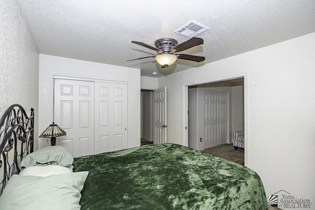 carpeted bedroom with ceiling fan and a textured ceiling