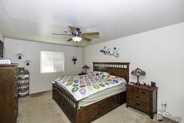 carpeted bedroom with ceiling fan and a textured ceiling