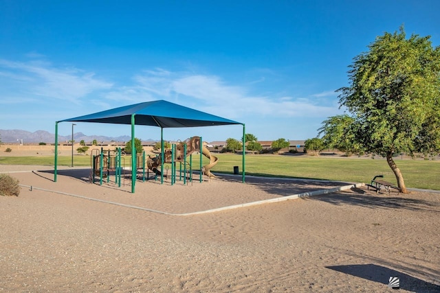 view of playground featuring a lawn and a mountain view