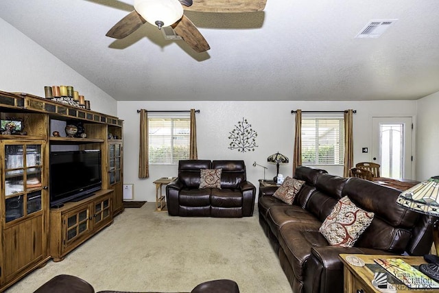 carpeted living room featuring ceiling fan and a textured ceiling