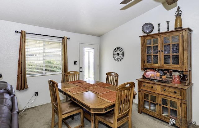 dining room featuring light carpet and lofted ceiling