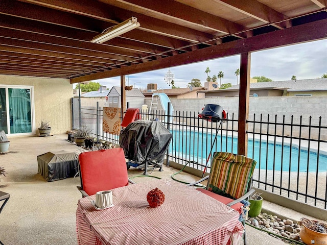 view of patio featuring a fenced in pool and a grill