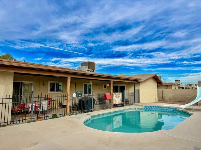 view of pool featuring central AC unit, a patio, and a water slide