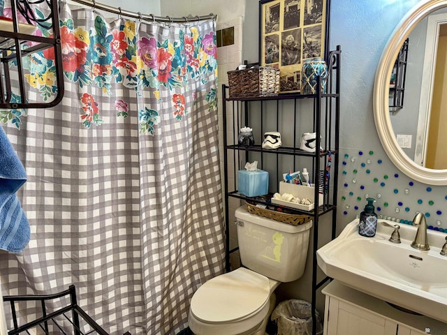 bathroom with vanity, curtained shower, and toilet