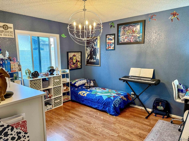 bedroom featuring a textured ceiling, an inviting chandelier, and light hardwood / wood-style flooring