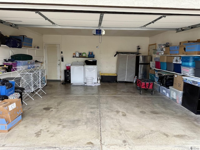 garage with a garage door opener and washer and clothes dryer