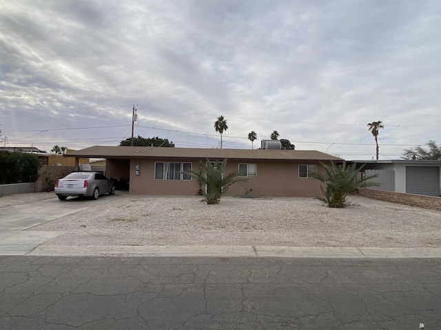 ranch-style home with a carport and central air condition unit