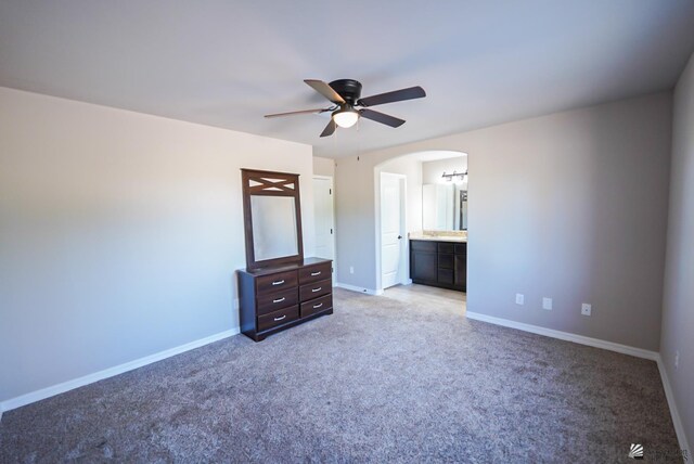 unfurnished bedroom featuring connected bathroom, ceiling fan, and light carpet