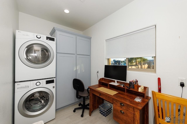 laundry room featuring cabinet space and stacked washer and clothes dryer