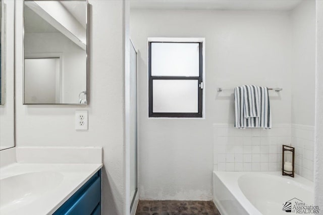 bathroom with a bath, a stall shower, and vanity