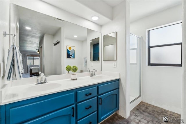 bathroom featuring double vanity, a sink, a shower stall, and ensuite bathroom