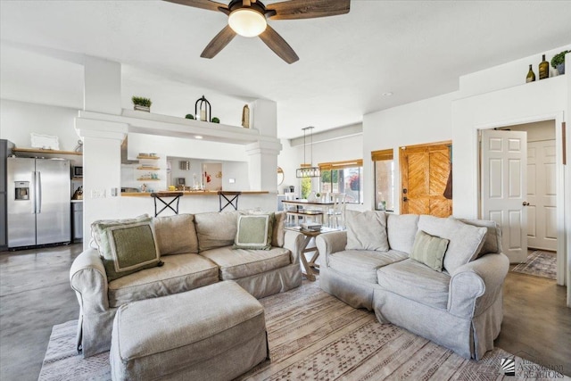 living room with ceiling fan and concrete floors