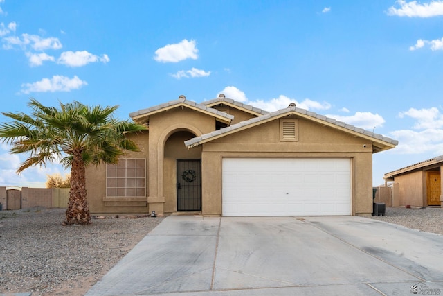 ranch-style house with a garage, driveway, fence, and stucco siding