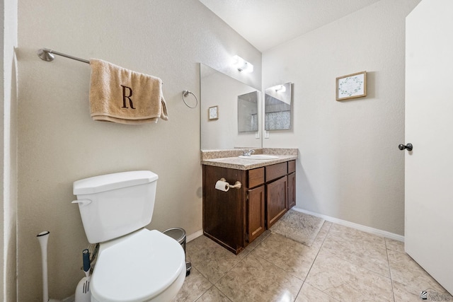 bathroom with toilet, tile patterned flooring, baseboards, and vanity