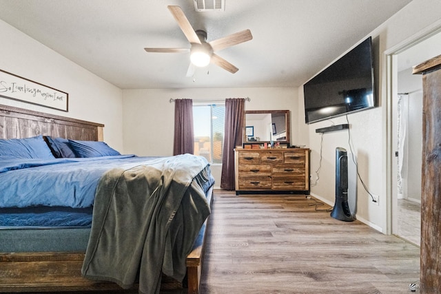 bedroom featuring ceiling fan, light wood-type flooring, and baseboards